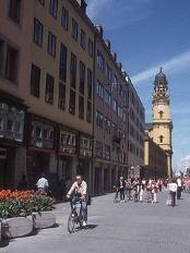 The picture of the Munich city centre and a bicyclist cycling towards the photographer cheapflightsia the online website tool which will help you in finding cheap flights to Munich and book airline tickets directly with airline flight operators in order to get the best flights from heathrow to Munich